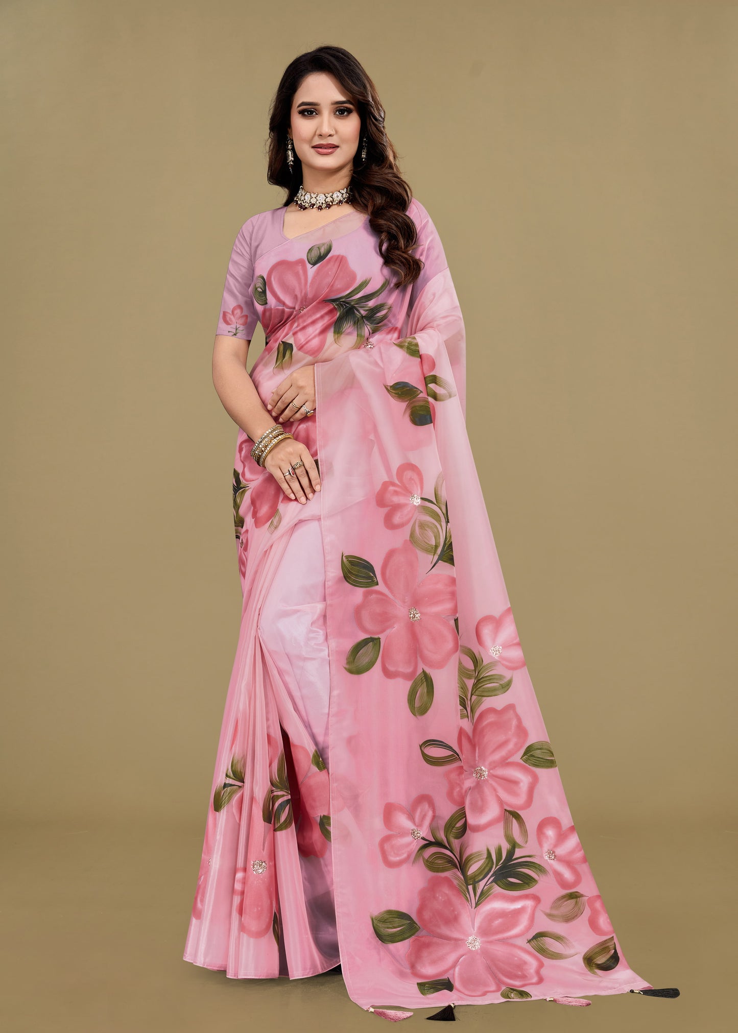 Woman wearing a pink floral saree against a beige background