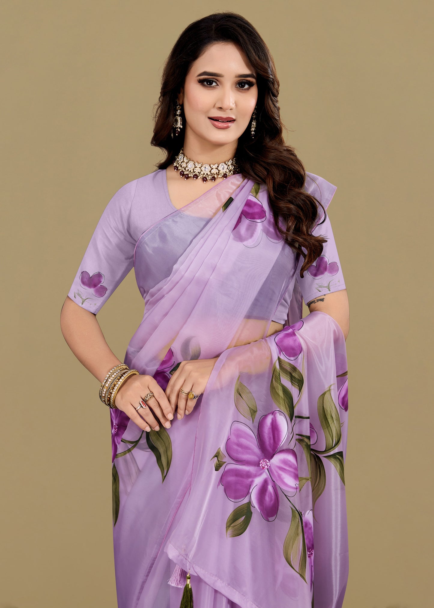 Woman wearing a lavender saree with floral patterns on a beige background